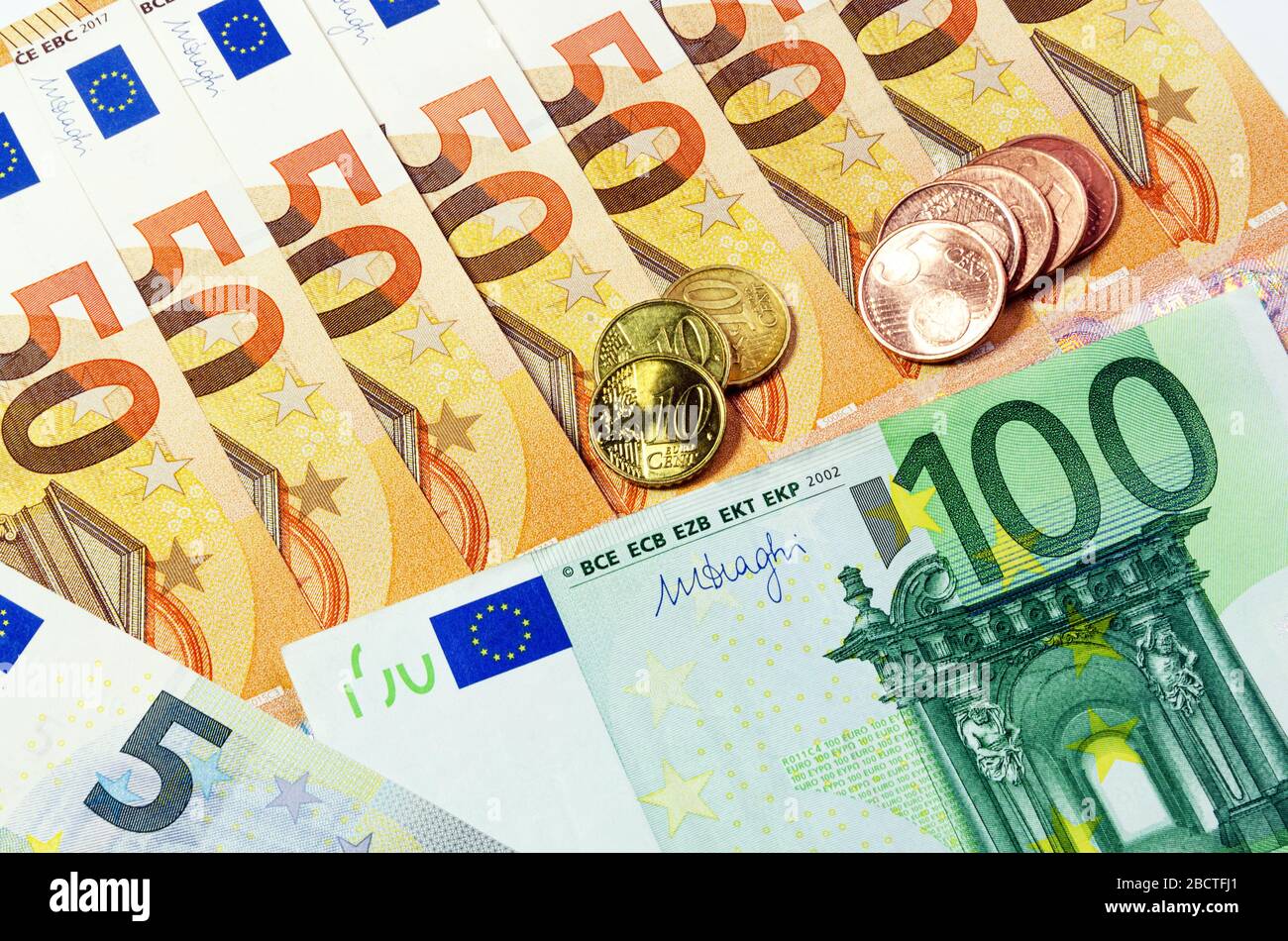 banknotes and coins. 5, 50 and 100 euros with Eurocent denominations of 5 and 10. The concept of income and spending. Stock Photo
