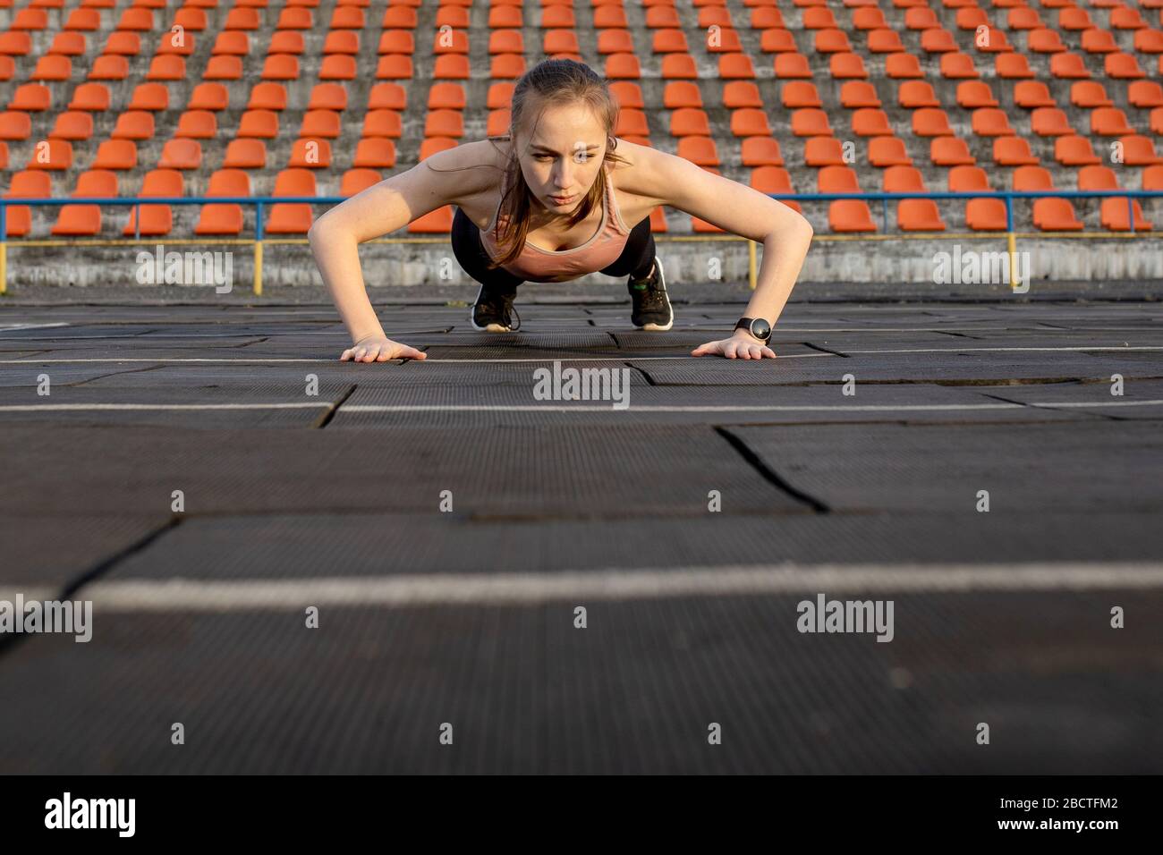 Female athlete preparing legs for cardio workout. Fitness runner doing warm-up routine. woman runner warm up outdoor. athlete stretching and warming Stock Photo