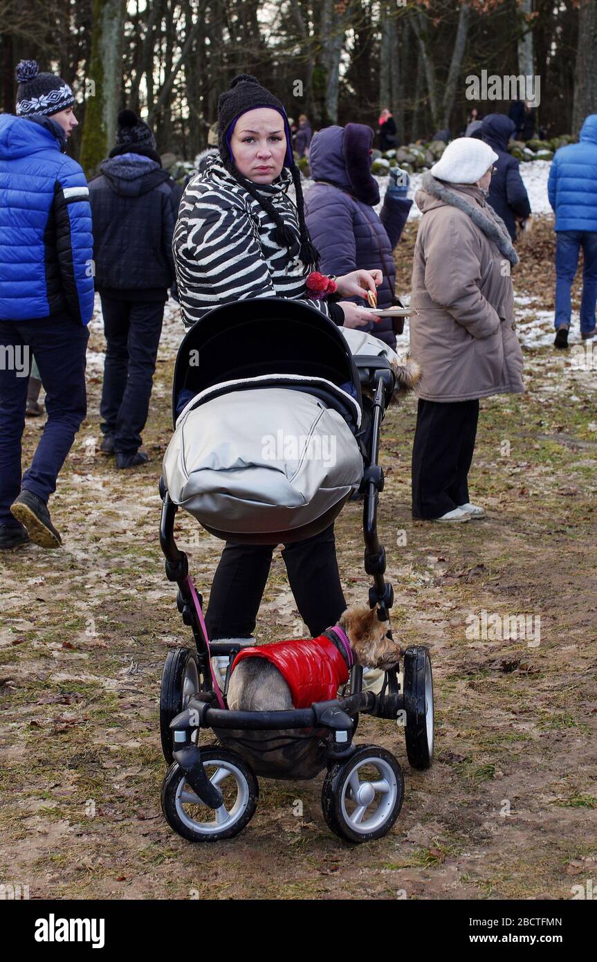 Stylish young lady with the small baby in the traditional Lithuanian festival called Uzgavenes Stock Photo