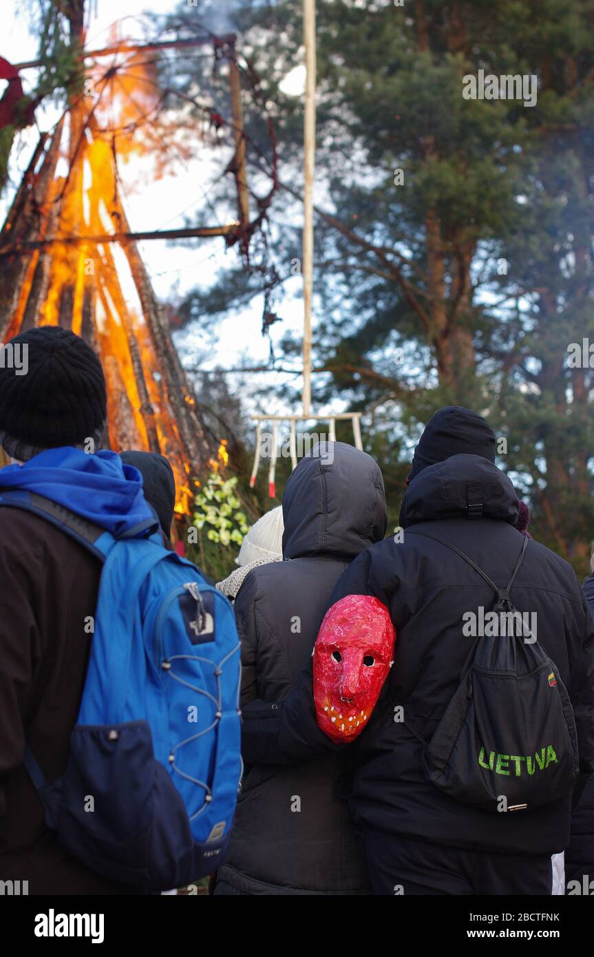 Masked people watching winter symbol doll More burning at the traditional festival Uzgavenes in Lithuania Stock Photo