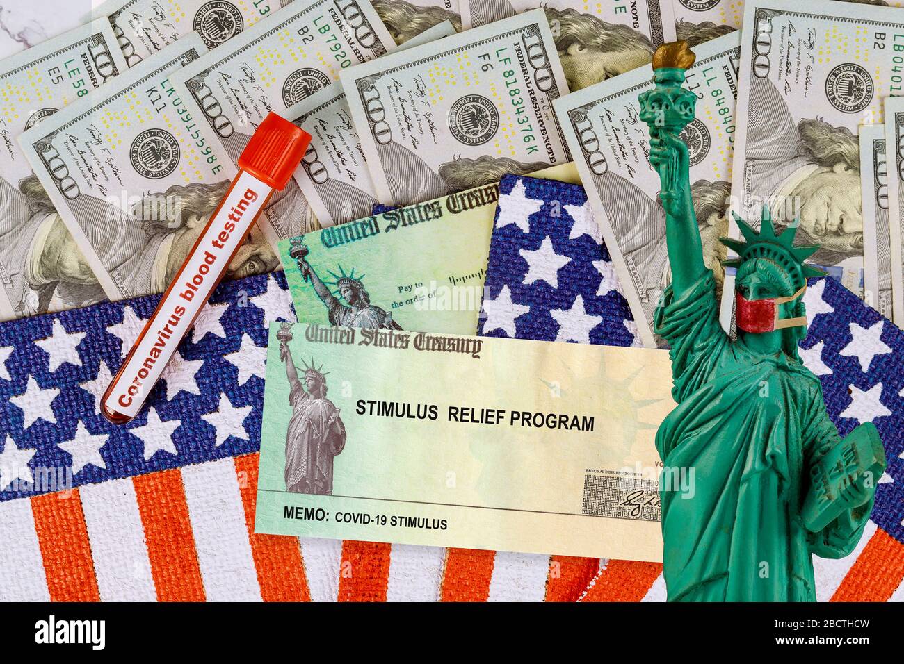 Stimulus financial bill individual checks from government US 100 dollar bills currency Global pandemic Covid 19 lockdown on American flag Stock Photo