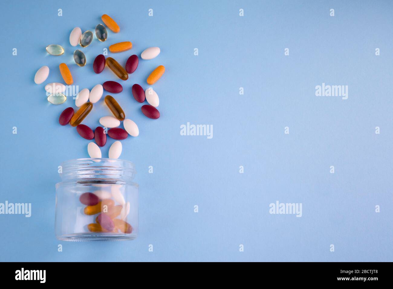 food-supplement-in-bottle-of-glass-in-blue-background-2BCTJT8.jpg