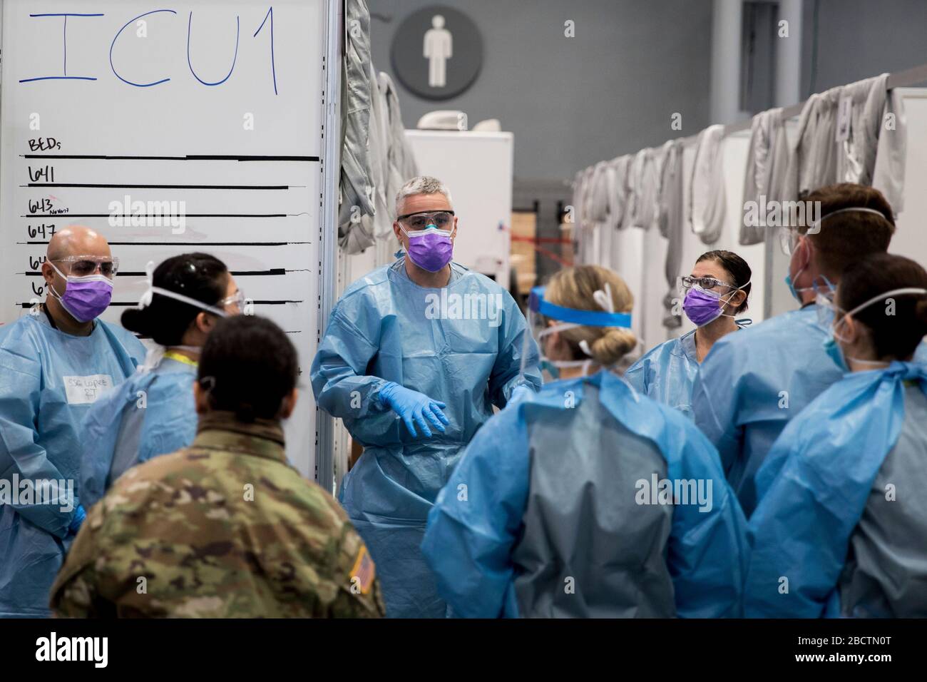 U.S. Army Maj. Sean Shirley, holds a meeting with staff in the intensive care unit bay at the Federal Medical Station COVID-19, coronavirus pandemic relief facility set up at the Jacob Javits Center April 4, 2020 in New York City, New York. Stock Photo