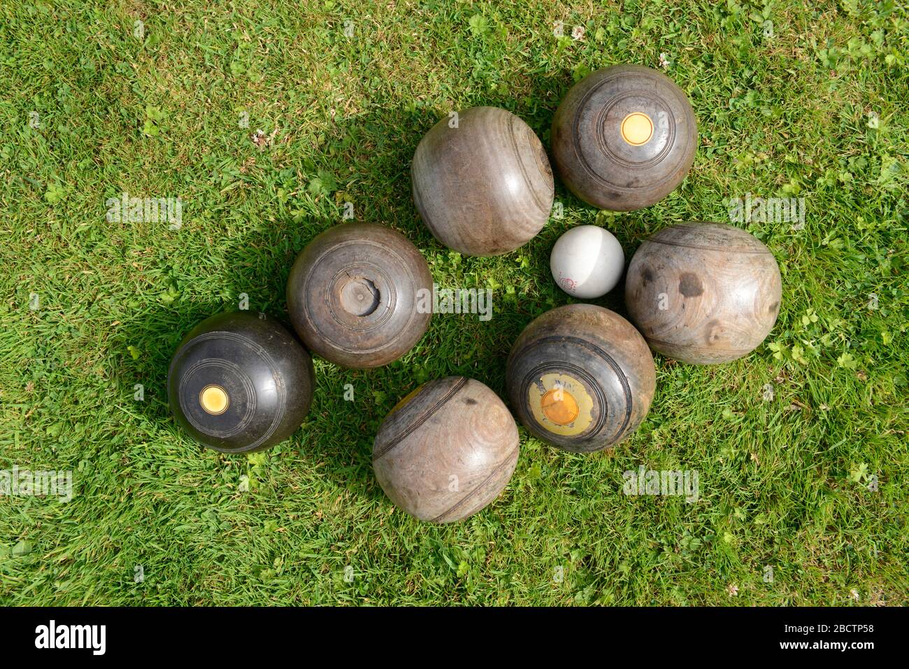Seven old, period bowls balls made of lignum vitae with a jack ball at Monk's house, once the home of Virginia Woolf, at Rodmell in East Sussex, UK Stock Photo