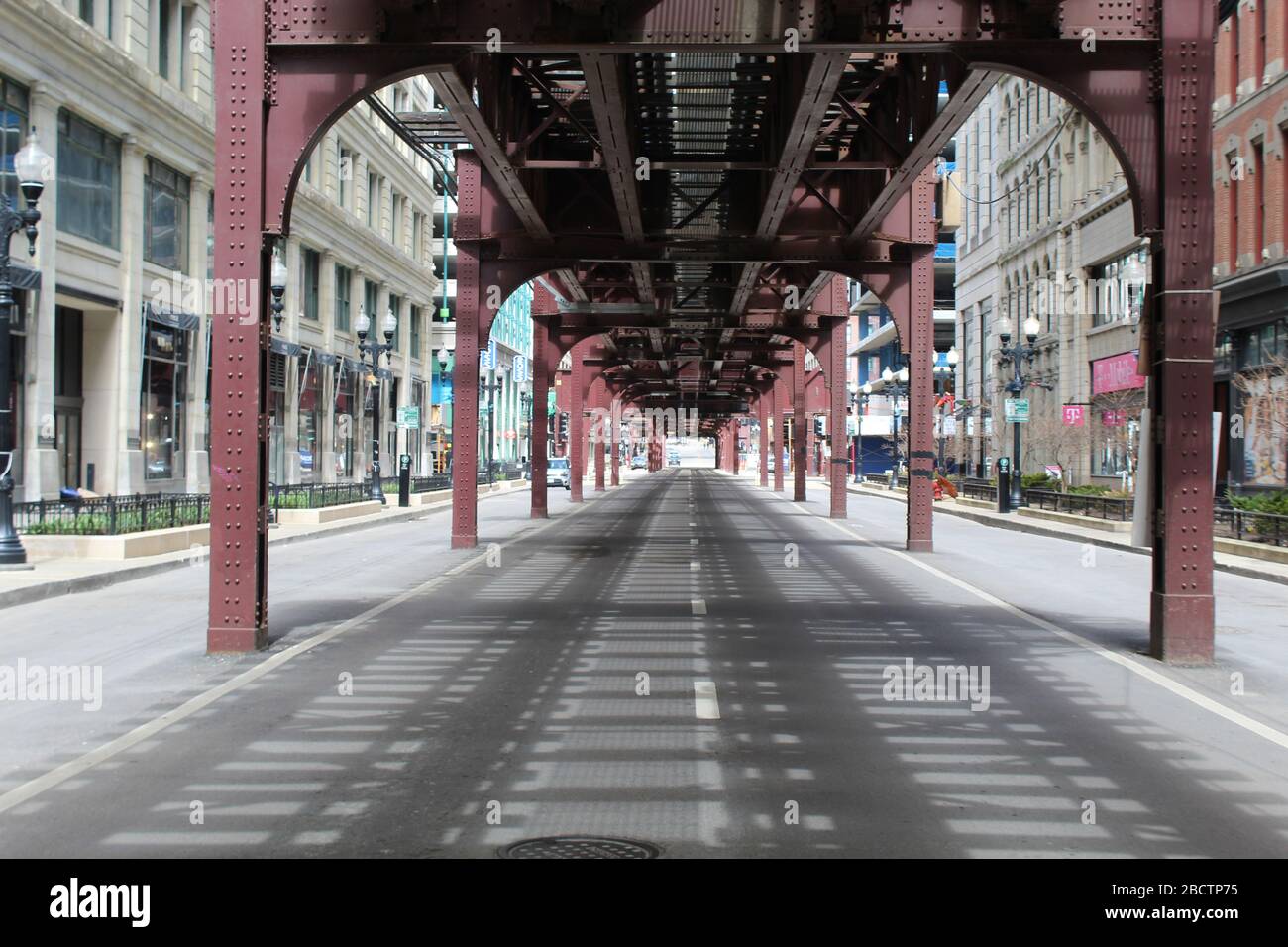 Nearly deserted Wabash Avenue in downtown Chicago with the elevated tracks above during the COVID-19 shelter-in-place order Stock Photo