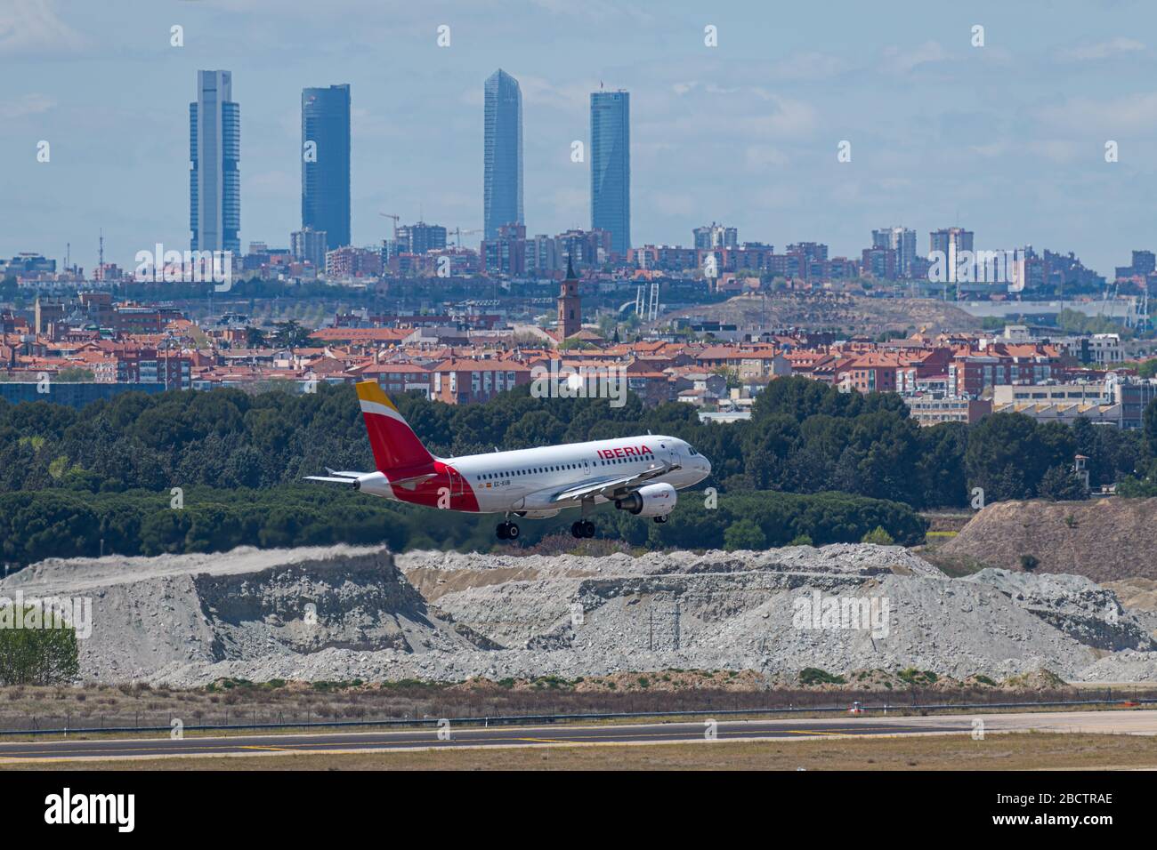 MADRID, SPAIN - APRIL 14, 2019: Iberia Airlines Airbus A319 passenger plane landing at Madrid-Barajas International Airport Adolfo Suarez In the backg Stock Photo