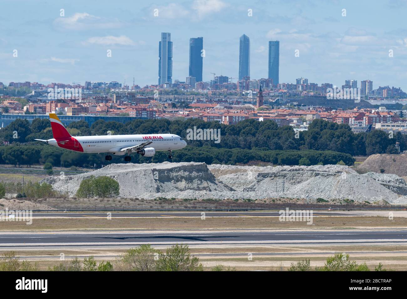 MADRID, SPAIN - APRIL 14, 2019: Iberia Airlines Airbus A320 passenger plane landing at Madrid-Barajas International Airport Adolfo Suarez In the backg Stock Photo