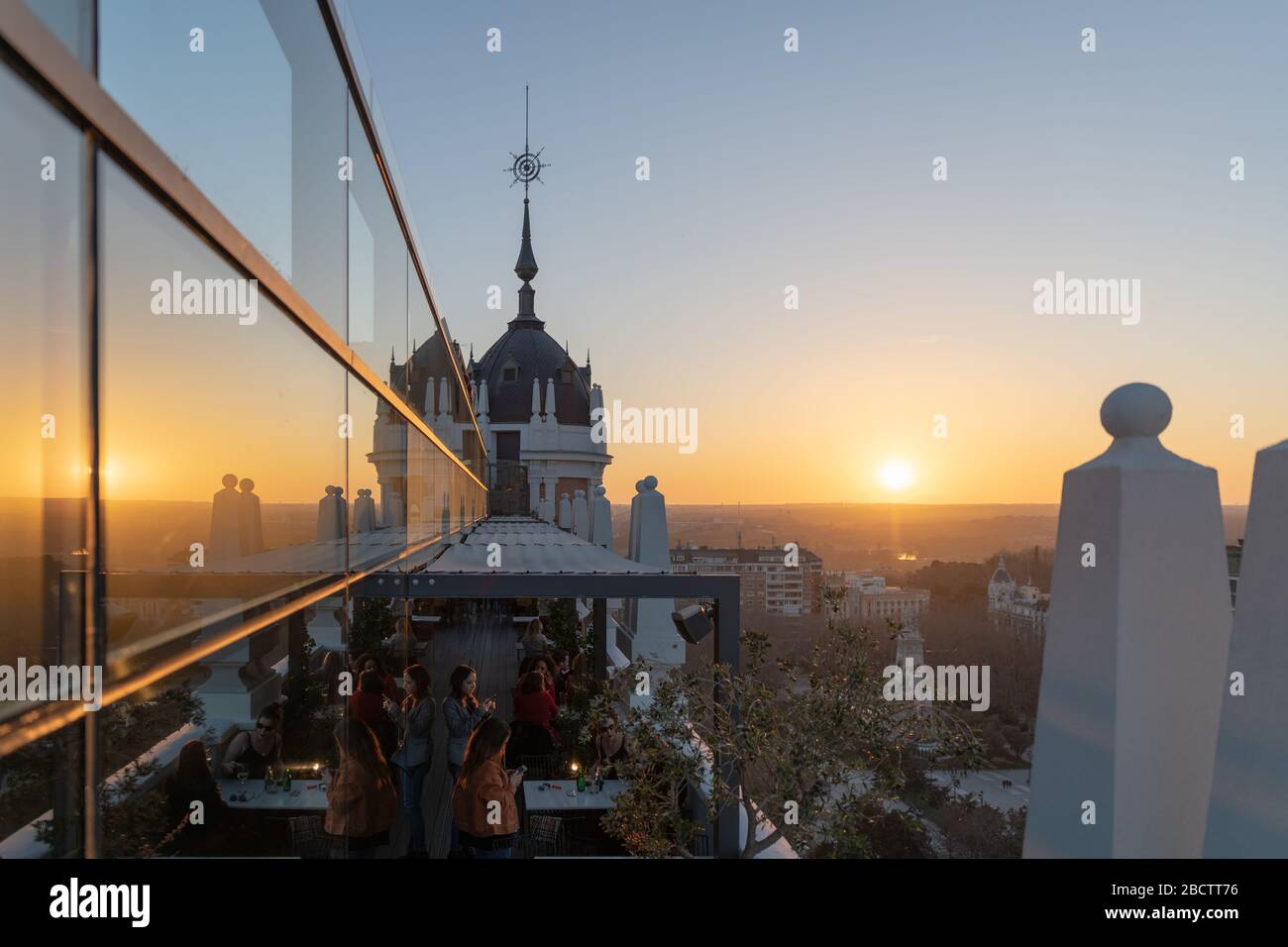 MADRID, SPAIN - FEBRUARY 24, 2019: Clients relaxing and having an aperitif on one of the many hotel rooftop terraces during the sunset in Madrid. Stock Photo
