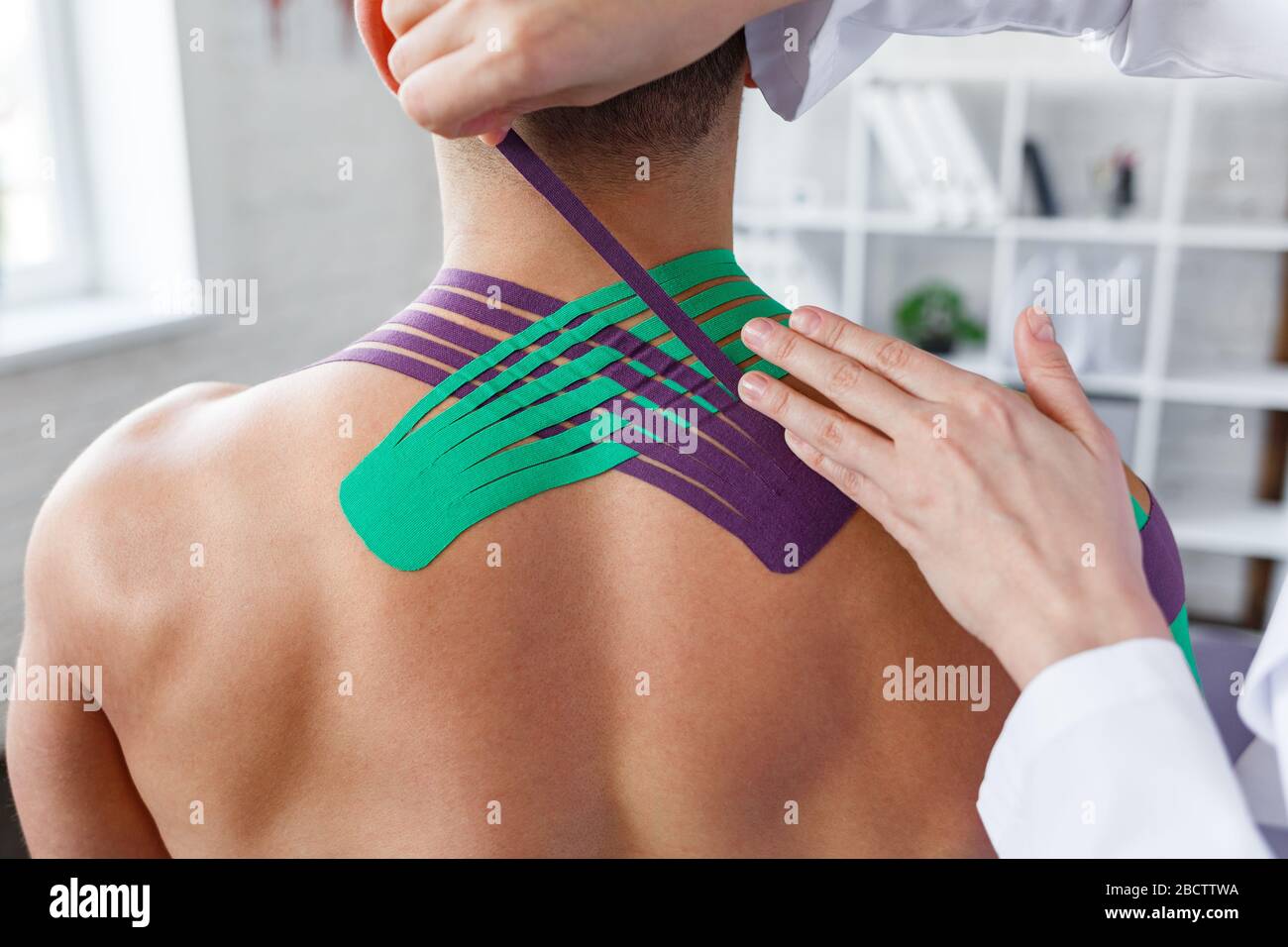 Kinesiology taping. Physical therapist applying kinesiology tape to patient neck. Therapist