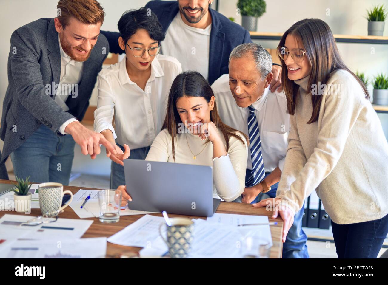 Working Smiling Group of business workers smiling happy and confident. One of them ...