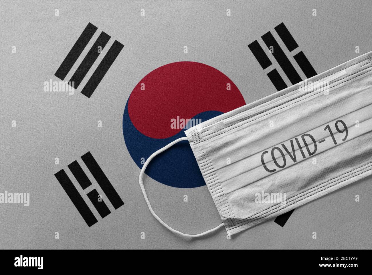 An individual face medical surgical mask on South Korea National Flag Background. Health mask. Protection against COVID-19 virus, influenza, SARS. Sav Stock Photo