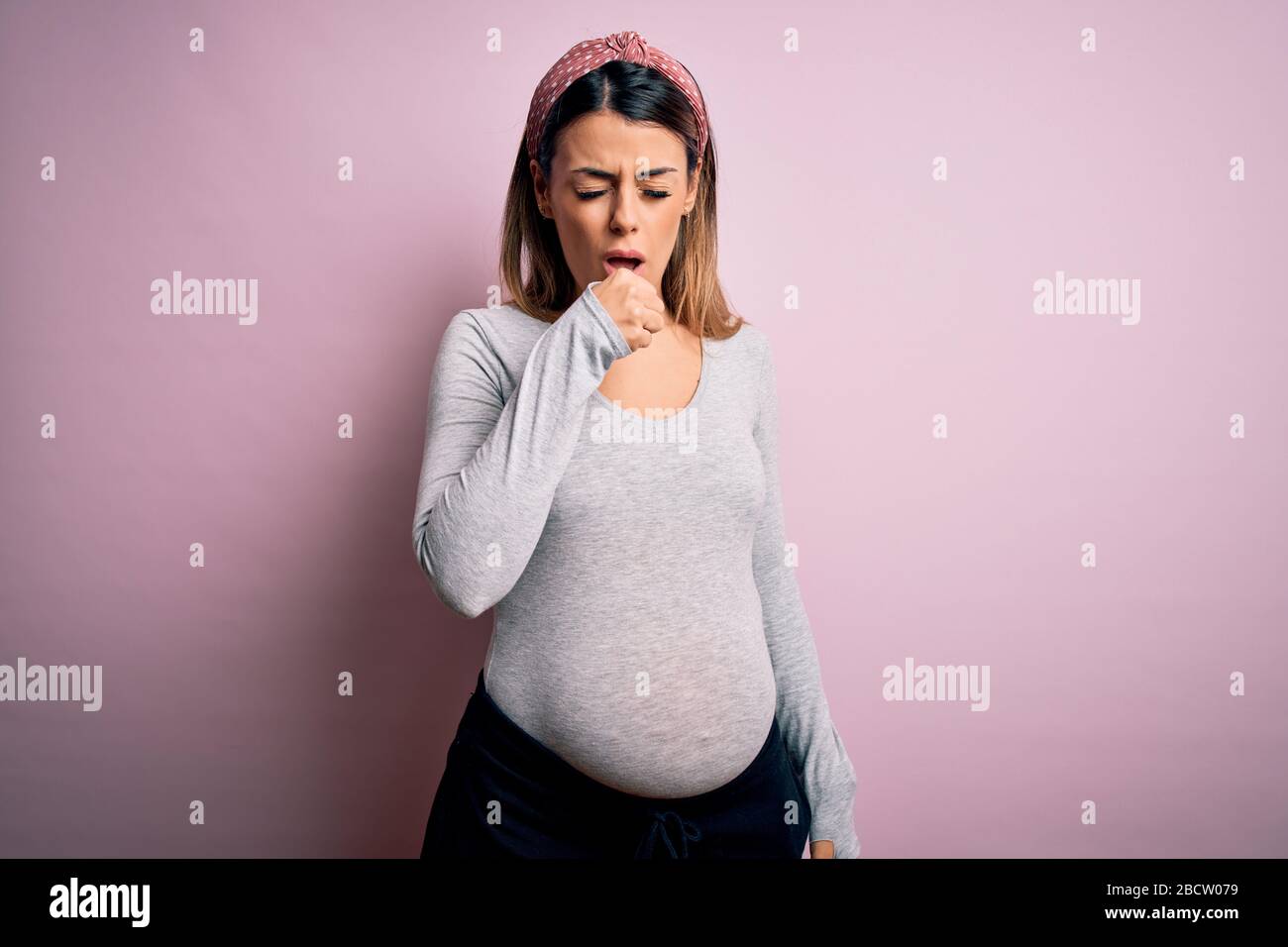 Young beautiful woman pregnant expecting baby over isolated