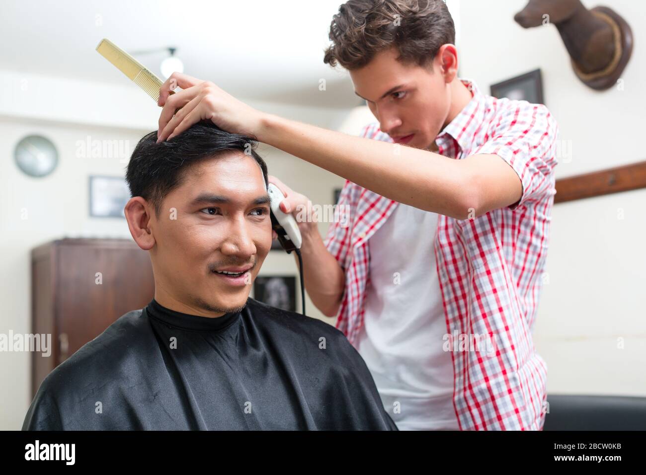 Hairdresser cutting hair with trimmer Stock Photo Alamy