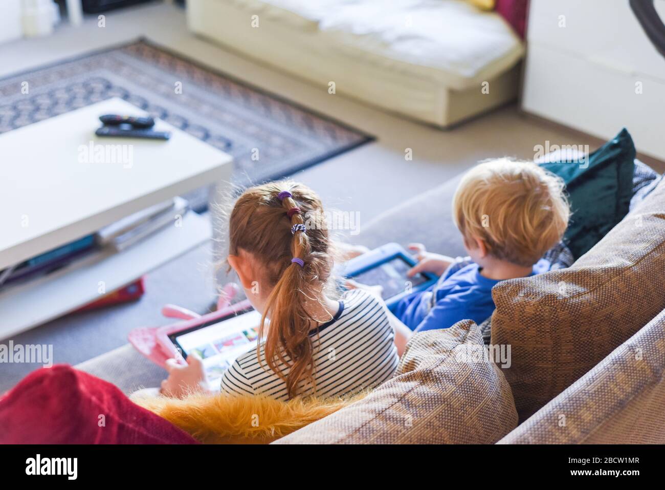 Children using their tablet device to play computer games and use ...