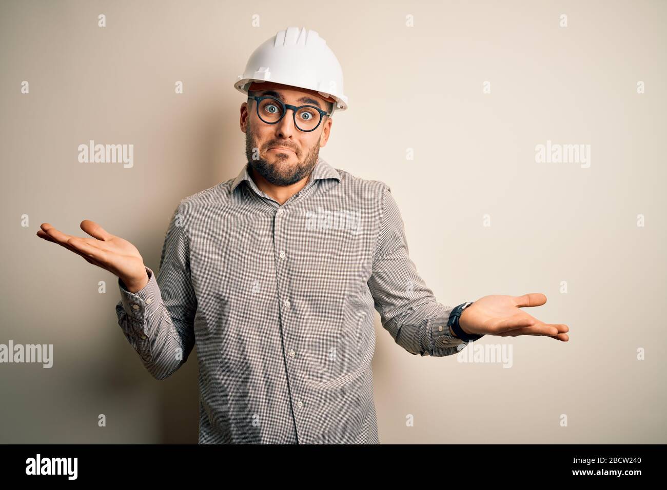 Young architect man wearing builder safety helmet over isolated ...
