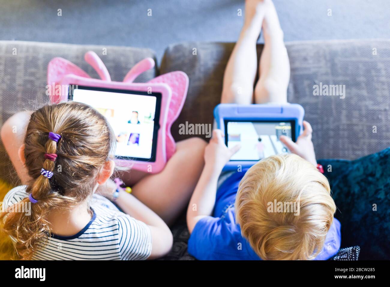 Children using their tablet device to play computer games and use ...