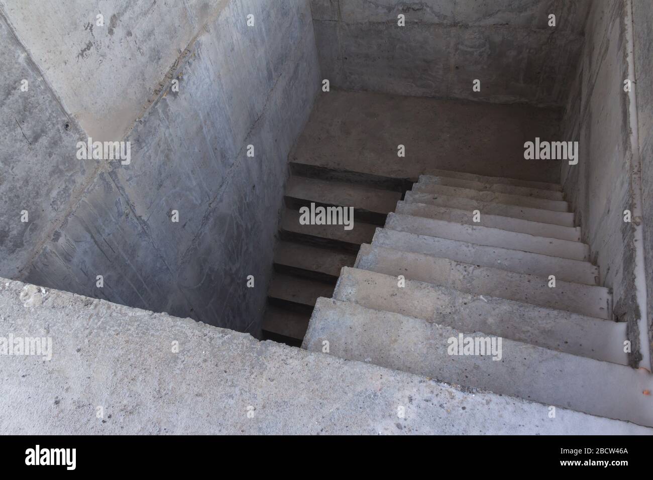 A ladder of concrete leading down. Concrete steps. Stairs down Stock
