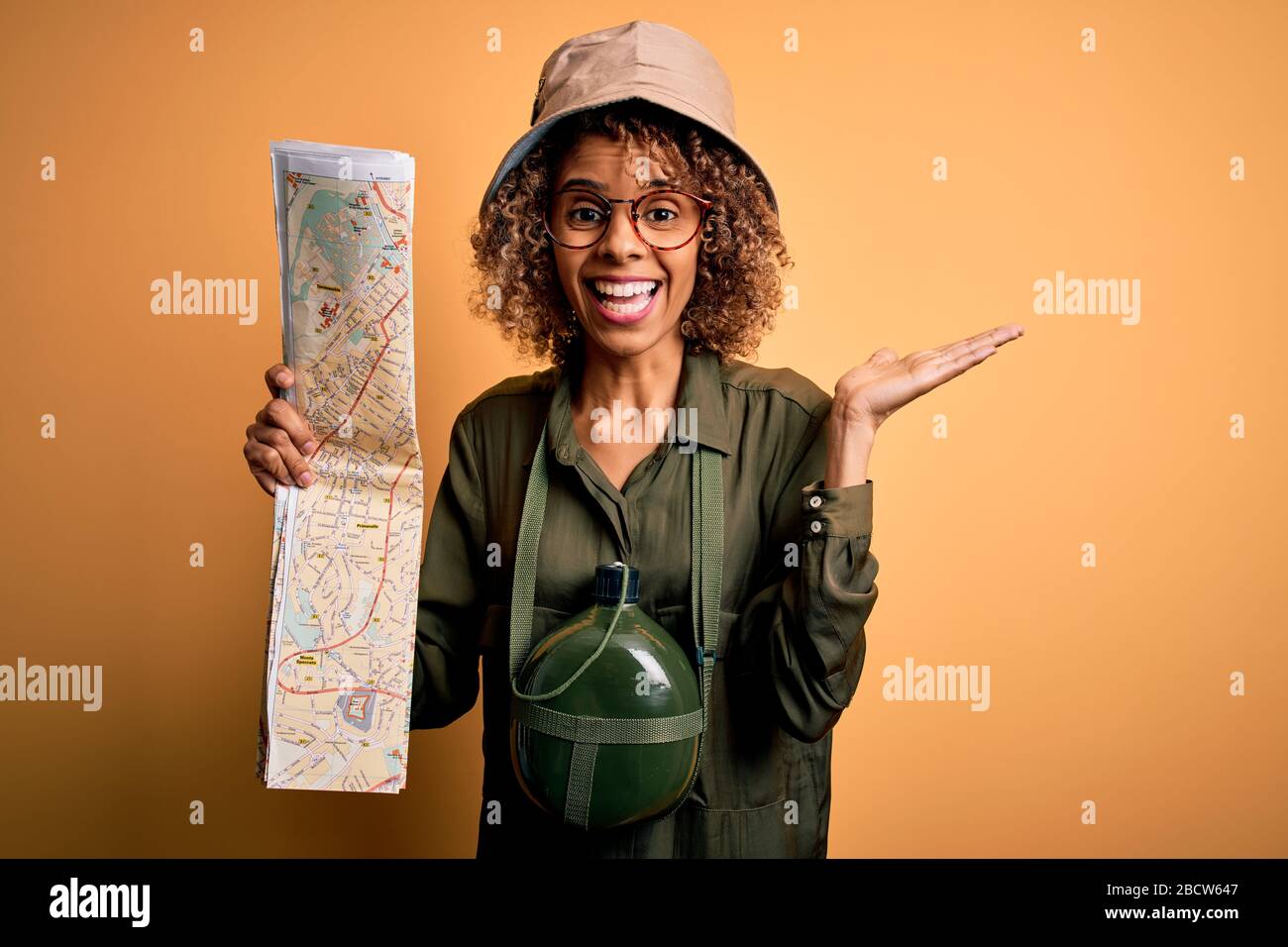 African american tourist woman wearing explorer hat and water canteen ...