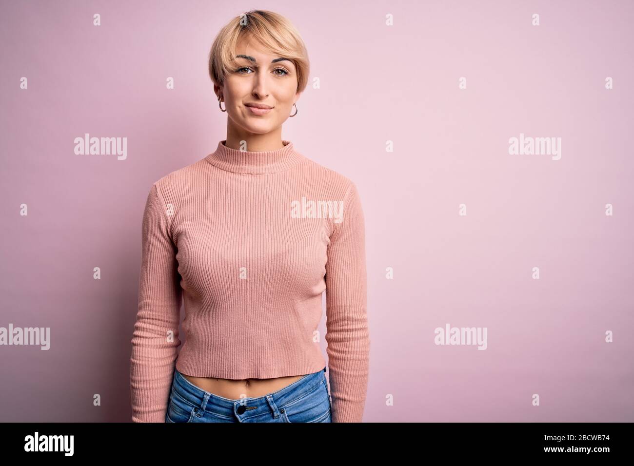 Young blonde woman with short hair wearing casual turtleneck sweater ...