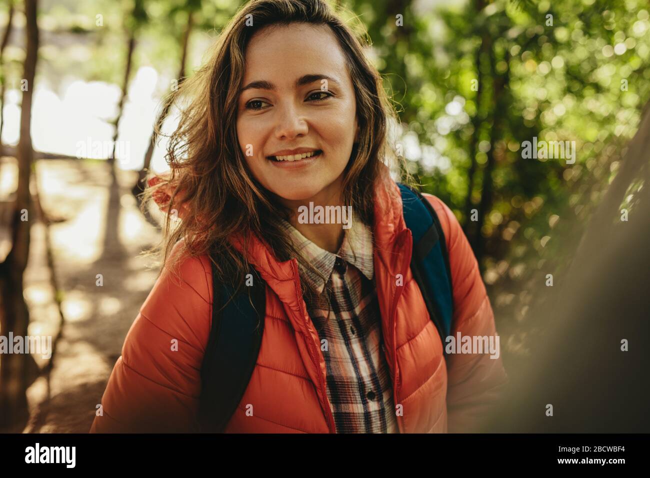 Closeup of a beautiful woman with backpack. Female camper in forest ...
