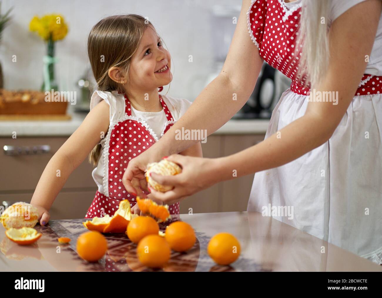 Young girl peeling oranges in the kitchen Stock Photo Alamy