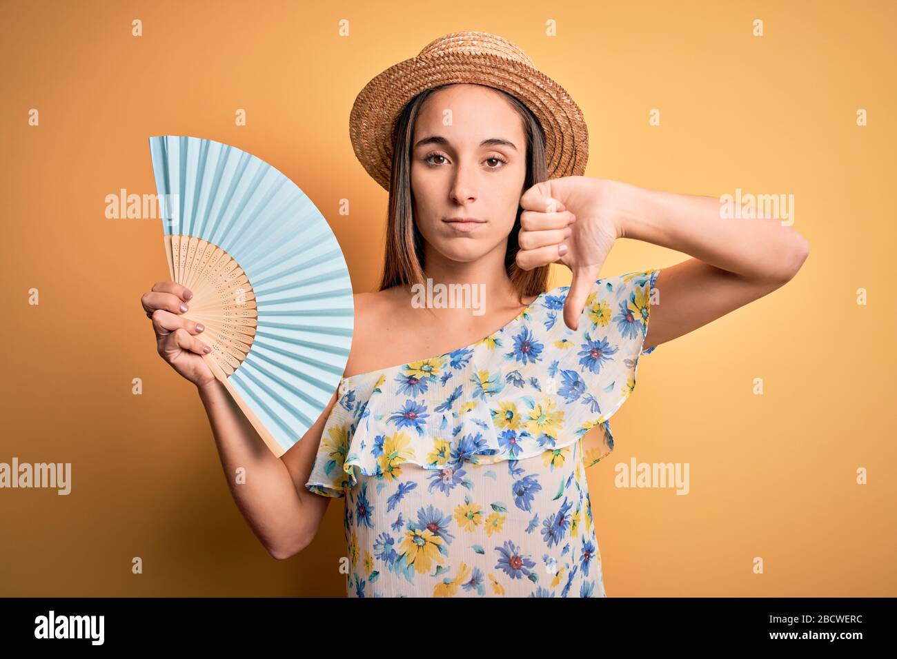 Young tourist woman on vacation wearing summer hat holding hand fan ...