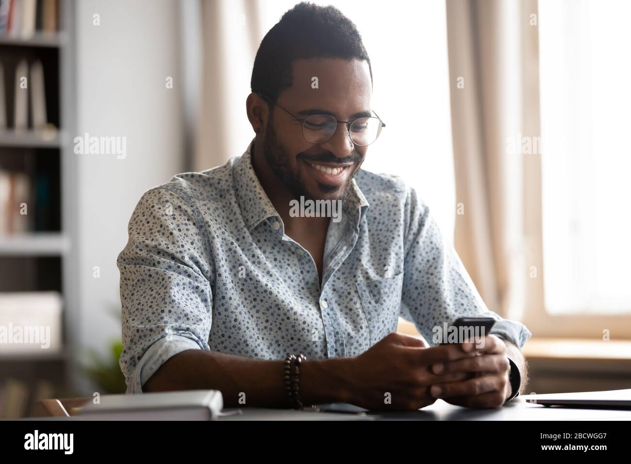 Smiling biracial man have fun using modern smartphone Stock Photo