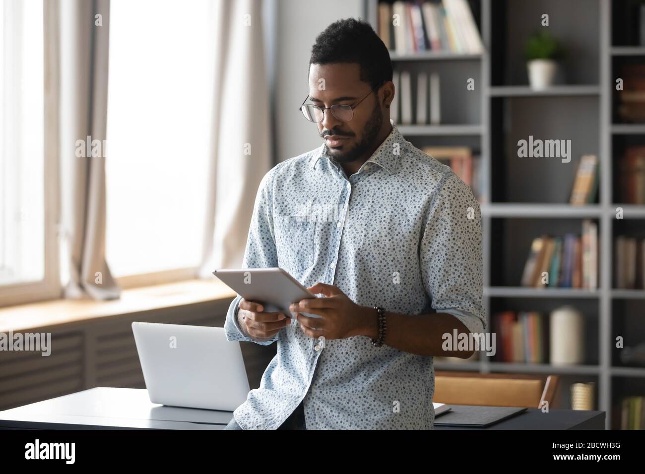 African American man browsing internet on tablet Stock Photo