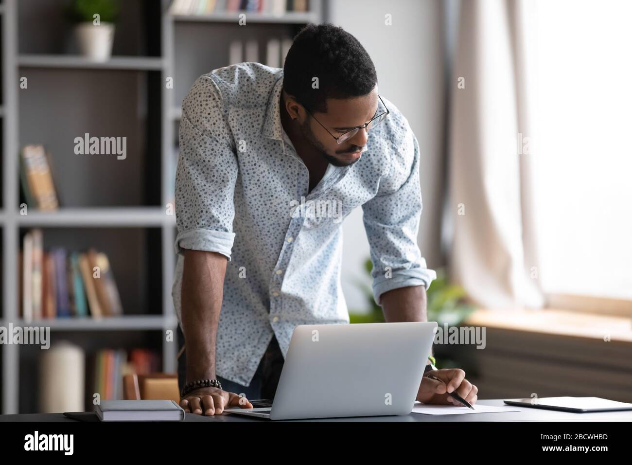 Focused biracial man busy working making notes Stock Photo