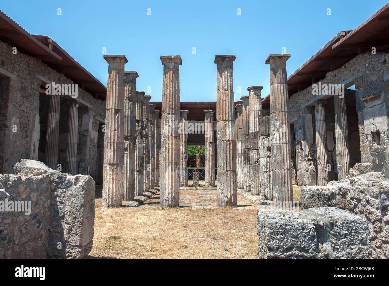 Ancient Doric columns stand in the remains of the House of Marcus Epidius Rufus (also known as the House of the Diadumeni), Pompeii, Italy. Stock Photo