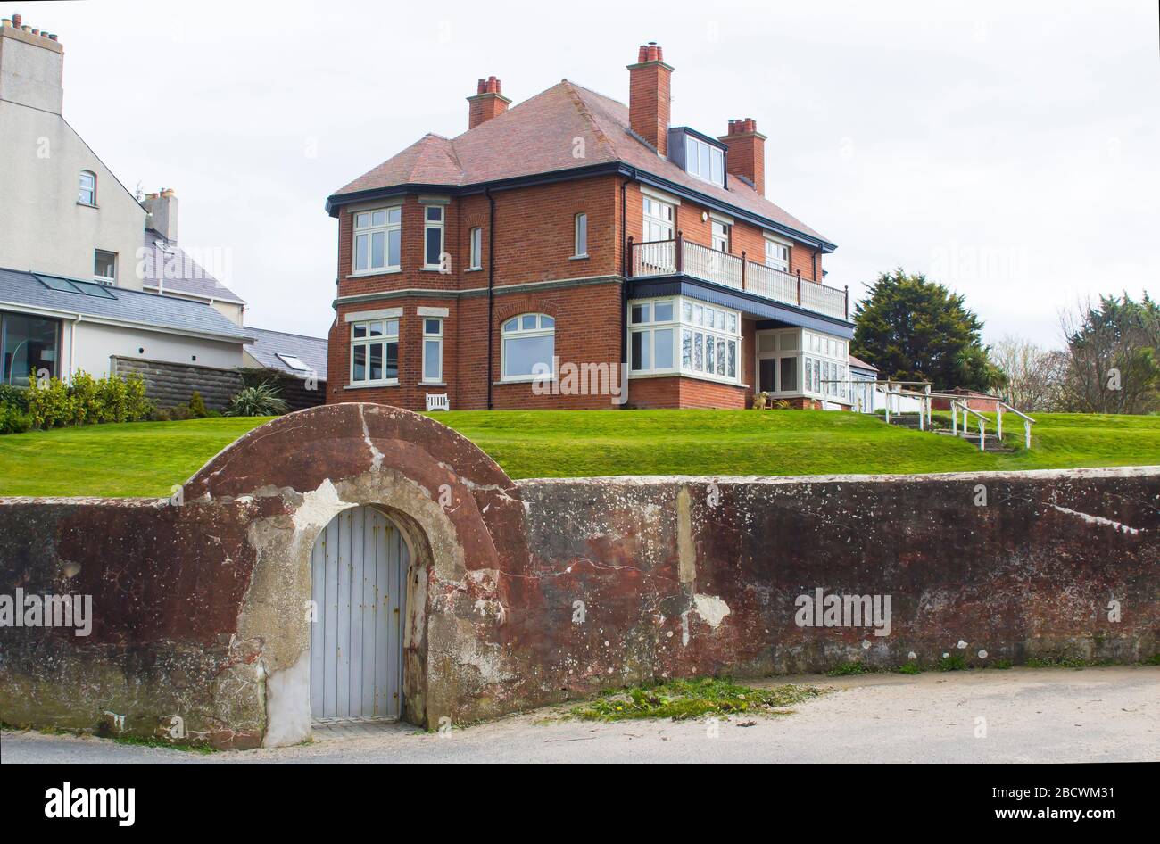 3 April 2020 An arched gateway leading from the seafront promenade in Ballyholme Bangor Northern Ireland into a private garden with a luxurious detach Stock Photo