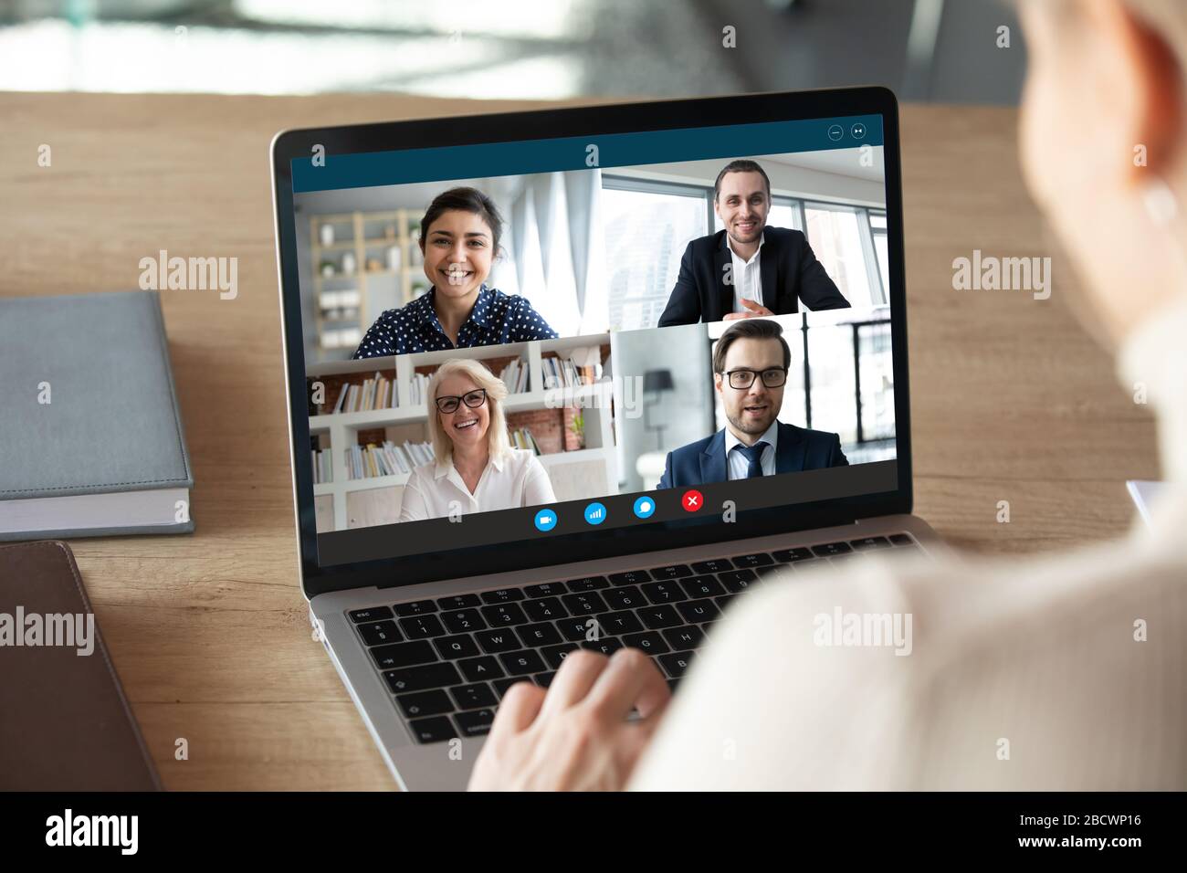 Computer screen view diverse businesspeople negotiating distantly using videocall Stock Photo