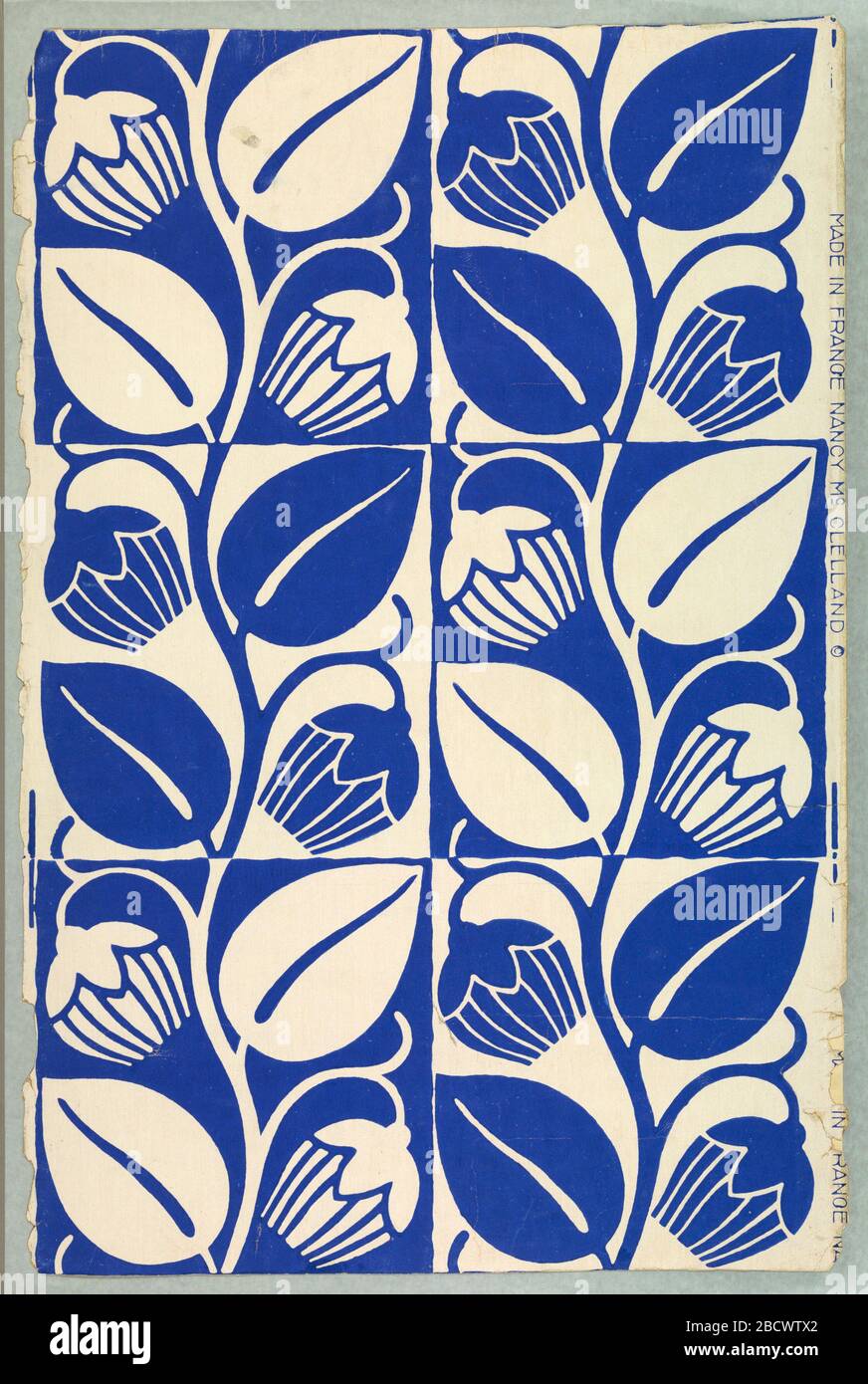 Sidewall. A highly stylized tulip design in alternating squares. One square consists of blue tulips and leaves on white field; the same design with color arrangement reversed is in opposite square. Printed for Nancy McClelland of New York City. Sidewall Stock Photo