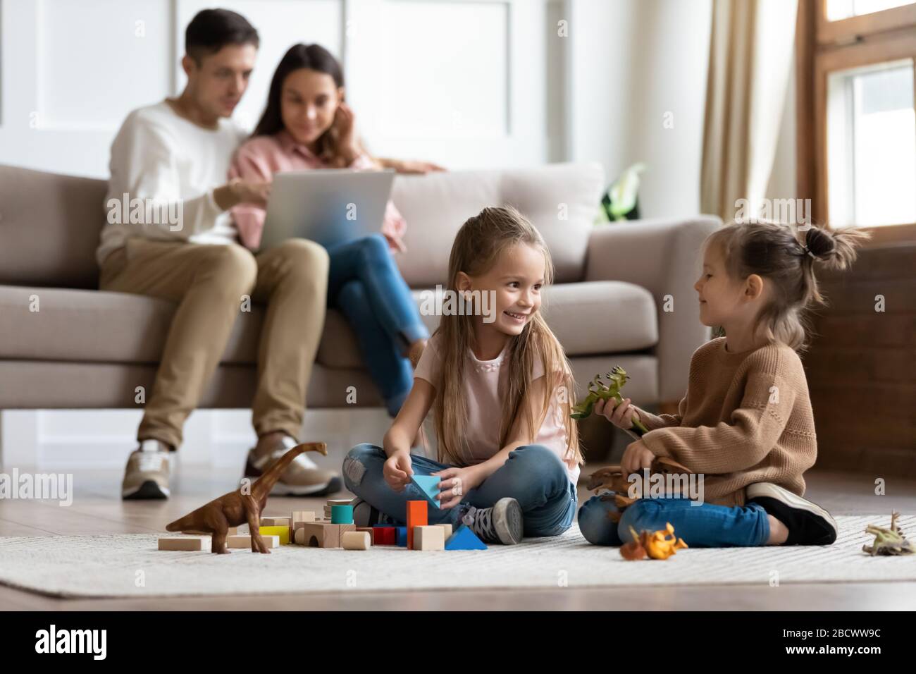 Happy family of four spending leisure time in living room. Stock Photo