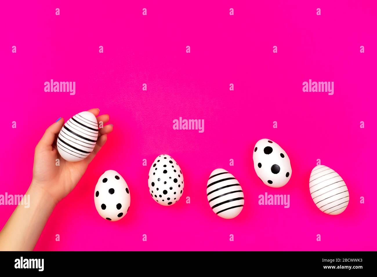 Different graphic hand-painted eggs on bright pink background. Easter concept. Place for text. Stock Photo