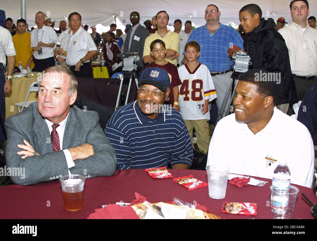 On the eve of the Washington Redskins' final preseason game, the Redskins Alumni Association and the Redskins Development Corporation put on a gala Welcome Home Luncheon at Redskin Park in Ashburn, Virginia on August 28, 2002. More than 500 fans, alumni and supporters attended the picnic style cook out which was held in a huge tent due to needed rain in the drought stricken area. As the rain fell players were honored, signed autographs and a good time was had by all. Redskin Alumni, pictured from left to right: Sam Huff, Hall of Fame linebacker; Bobby Mitchell, Hall of Fame wide receiver; and Stock Photo