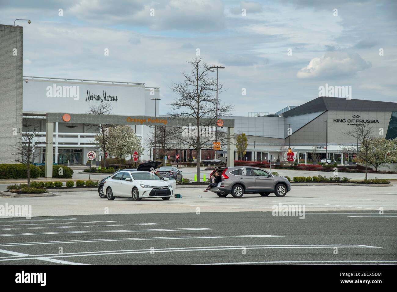 People practicing safe social distancing due to Coronavirus Covid-19 in parking lot of closed King Of Prussia Mall, Pennsylvania, USA Stock Photo