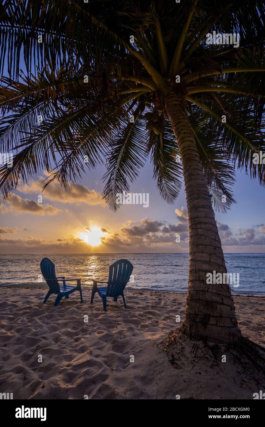 A perfect sunset with beach chairs, Grand Cayman Island Stock Photo