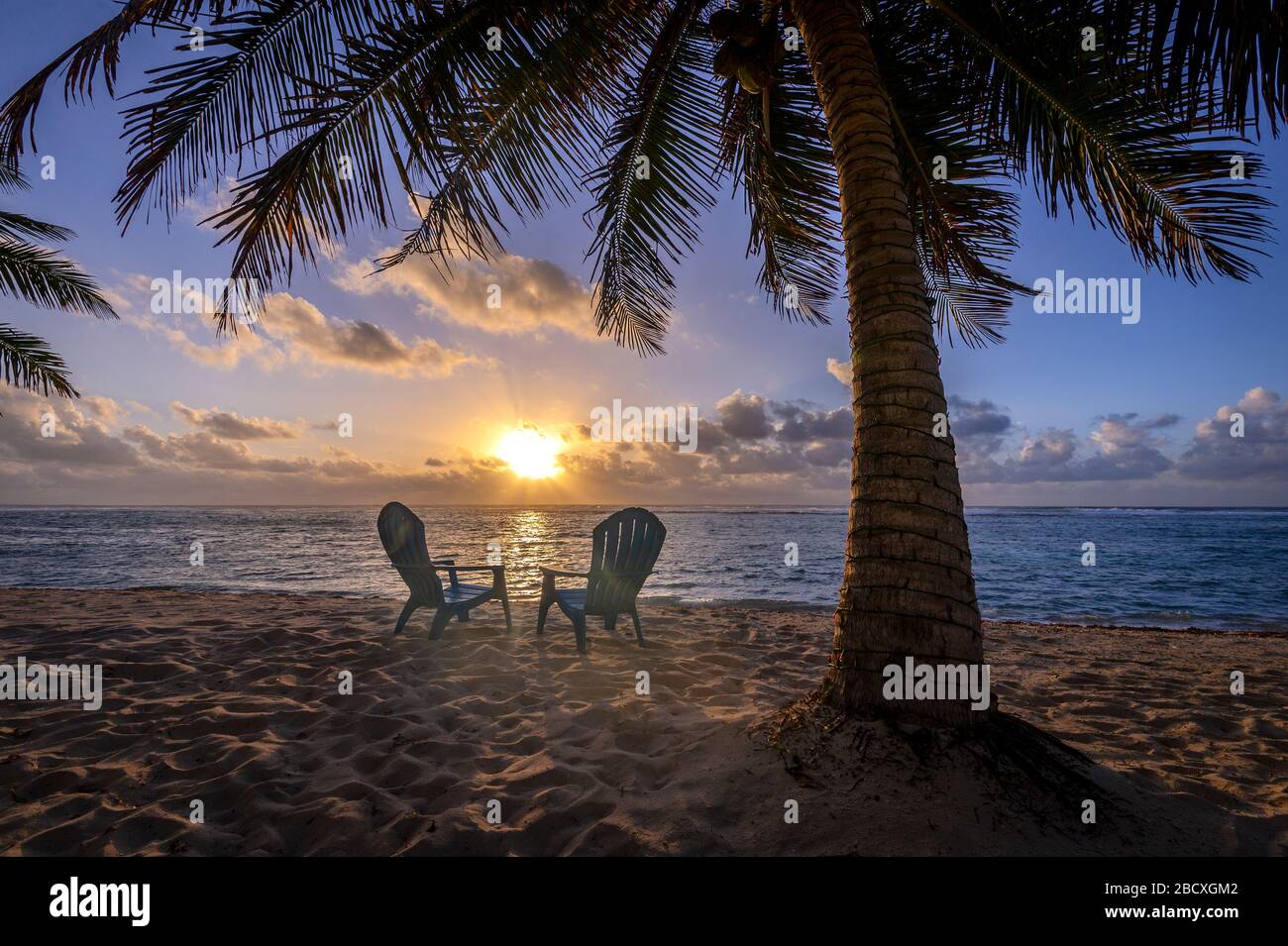 A perfect sunset with beach chairs, Grand Cayman Island Stock Photo