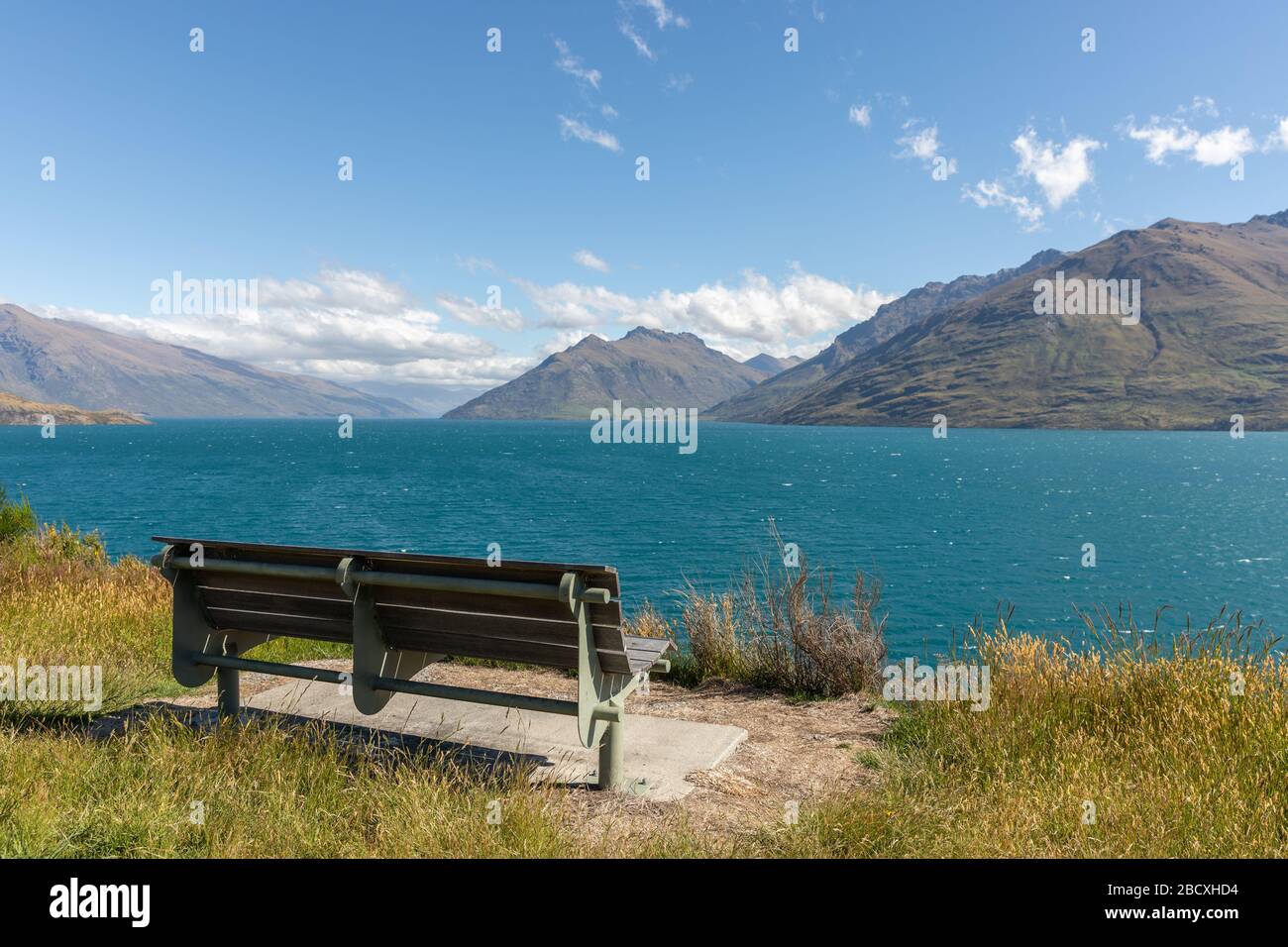 An empty bench along the Kelvin Peninsula and Lake Wakatipu Stock Photo