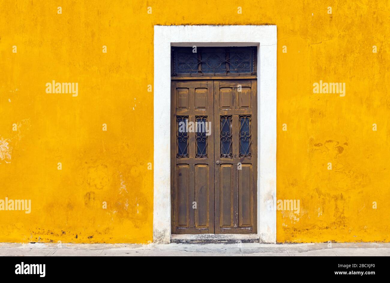 Yellow wall facade and door in the city center of Izamal, Yucatan Peninsula, Mexico. Stock Photo