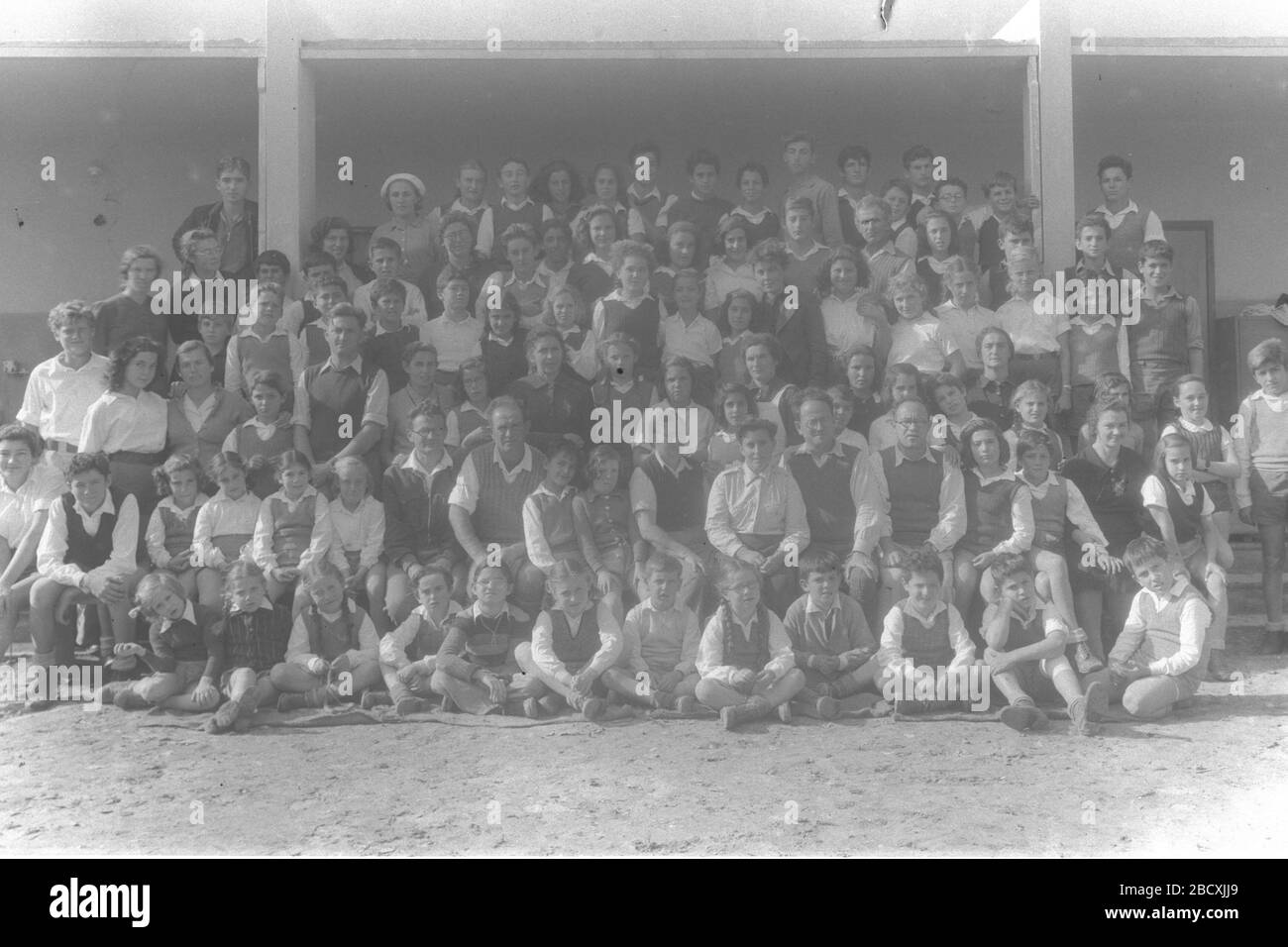 English A Group Picture Of The Teachers The Students Of Kibbutz Geva Photographed On The 25th Anniversary Of The Settlement U I I Ss E I O C U I U I O U I I U U O I O U E Ss O E I I E