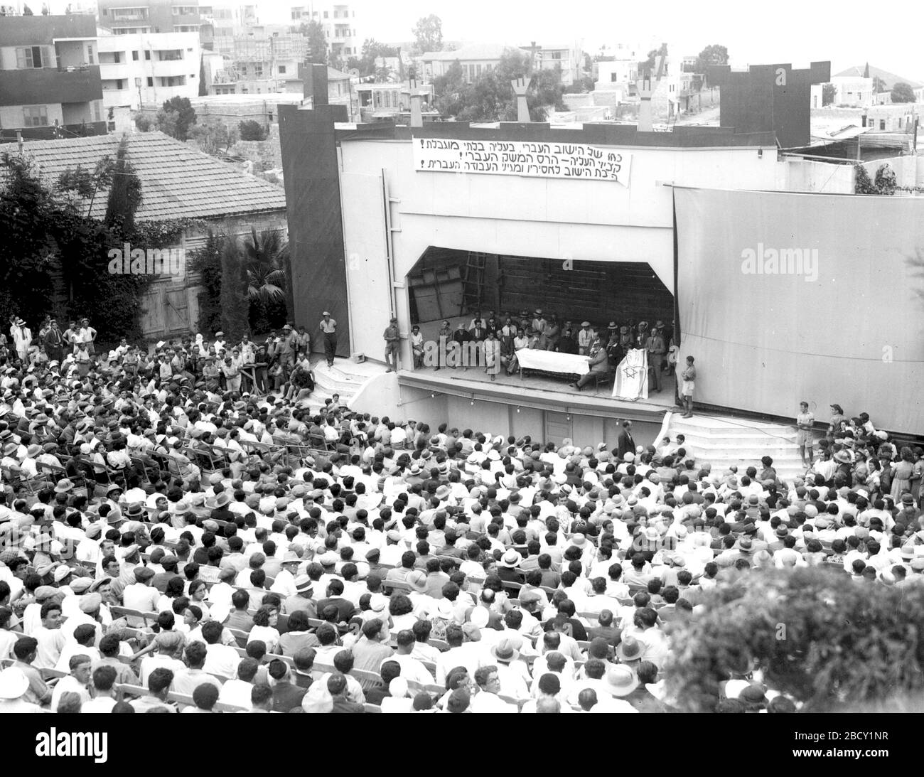 'English: A MASS RALLY IN HAIFA AGAINST THE CURTAILMENT OF JEWISH IMMIGRATION INTO PALESTINE. אסיפה המונית בחיפה המיועדת למחות נגד החלטת שלטונות המנדט להגביל את מספר היהודים הזכאים לעלות.; 8 August 1934; This is available from National Photo Collection of Israel, Photography dept. Goverment Press Office (link), under the digital ID D477-040.This tag does not indicate the copyright status of the attached work. A normal copyright tag is still required. See Commons:Licensing for more information.   English | עברית | македонски | +/−; Zoltan Kluger  (1896–1977)        Alternative names  Qlwger, Zw Stock Photo