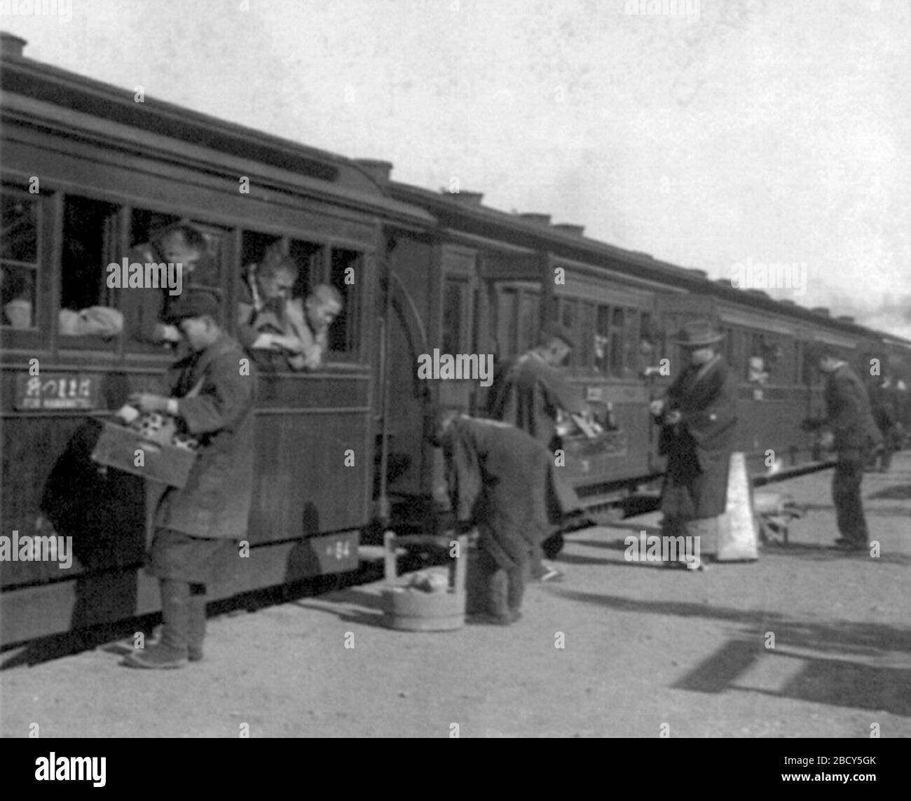 'Ten minutes for refreshments, Japan / Passengers of train leaning out windows, being served refreshments by men on railroad platform.  日本語: 10分間の休憩、客車の窓を開けて駅弁を買う; circa 1902 date QS:P,+1902-00-00T00:00:00Z/9,P1480,Q5727902; This image  is available from the United States Library of Congress's Prints and Photographs division under the digital ID cph.3b42202.This tag does not indicate the copyright status of the attached work. A normal copyright tag is still required. See Commons:Licensing for more information.   العربية | беларуская (тарашкевіца) | čeština | Deutsch | English | español | فارس Stock Photo