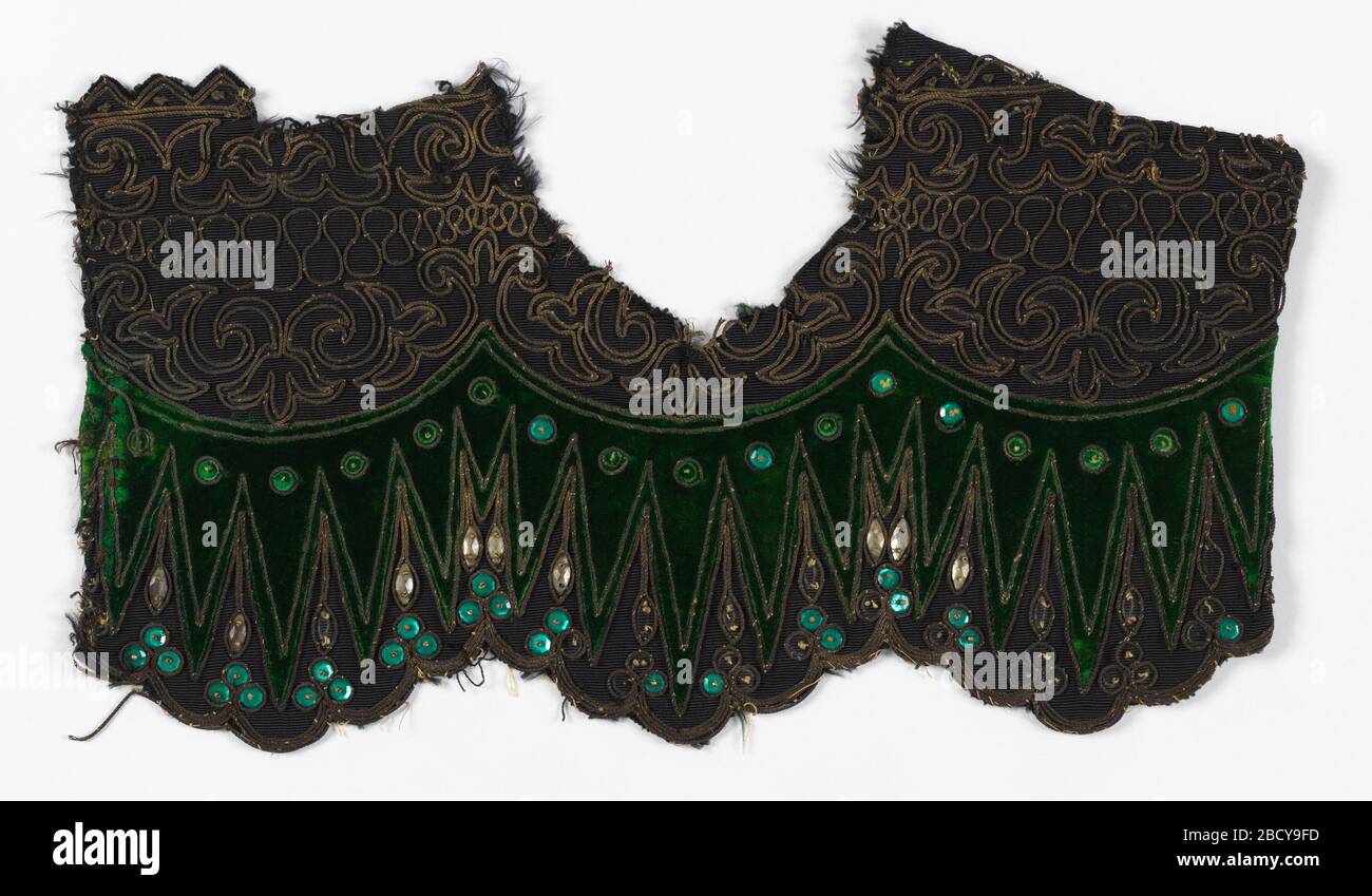 Embroidery sample. Research in ProgressFragment of black, weft-ribbed silk cut at the bottom into three wide shallow scallops, in turn scalloped, with applied section of bottle green velvet; double row of couched gold cord outlining velvet and encircling applied faceted green glass sequins. Embroidery sample Stock Photo
