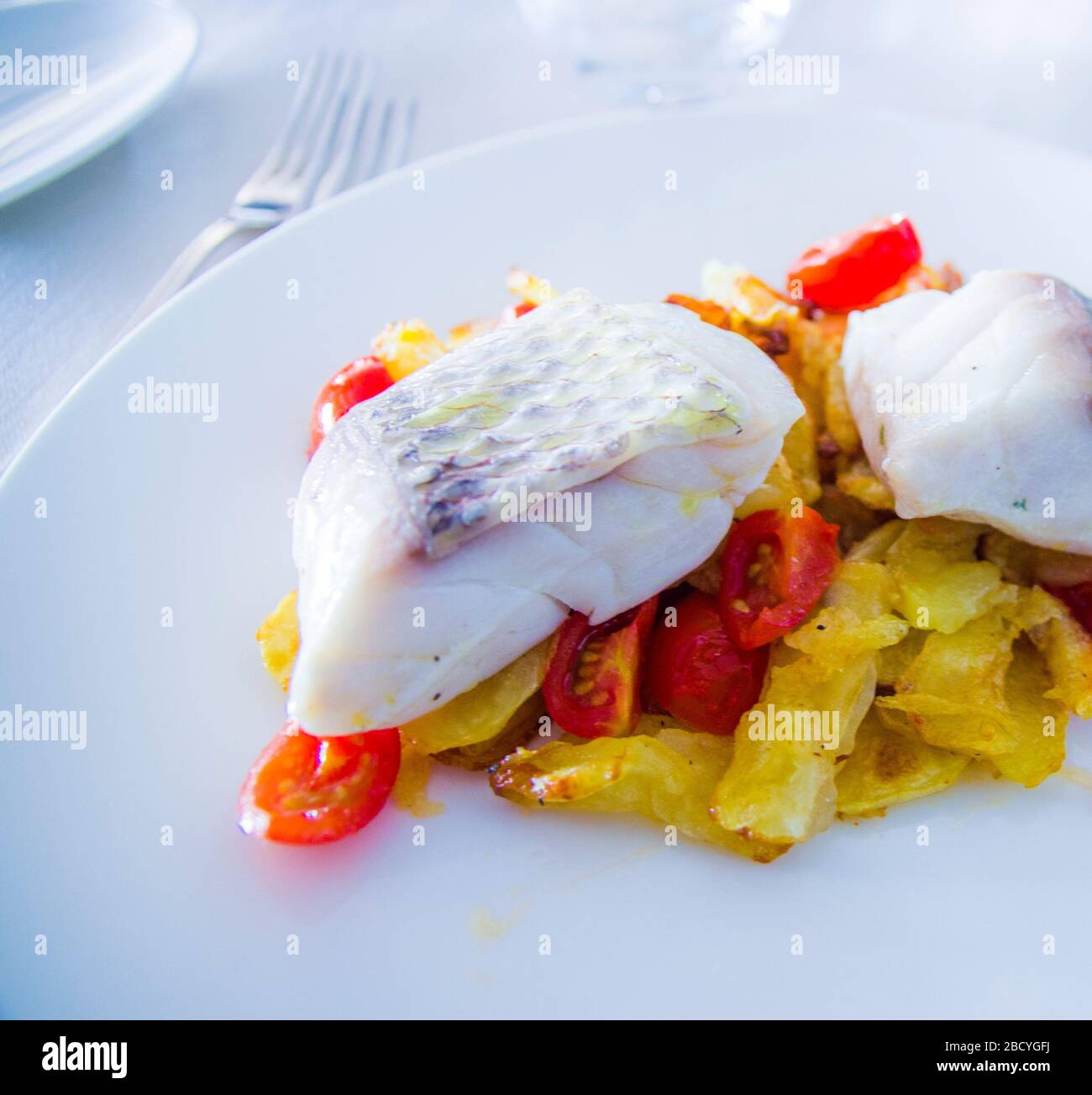 baked sea bass with fried vegetables and cherry tomatoes sautéed with