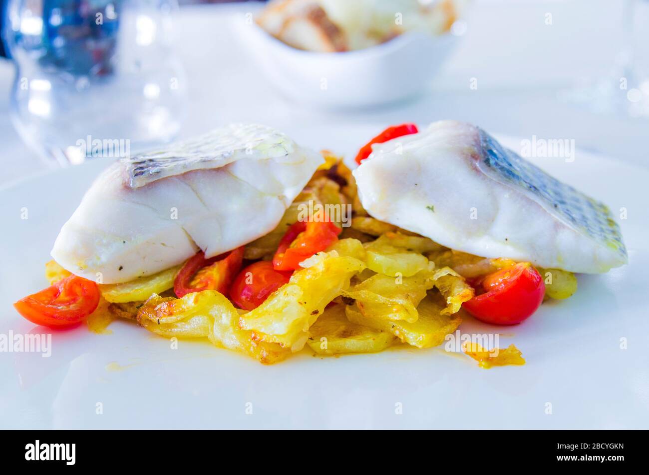 baked sea bass with fried vegetables and cherry tomatoes sautéed with
