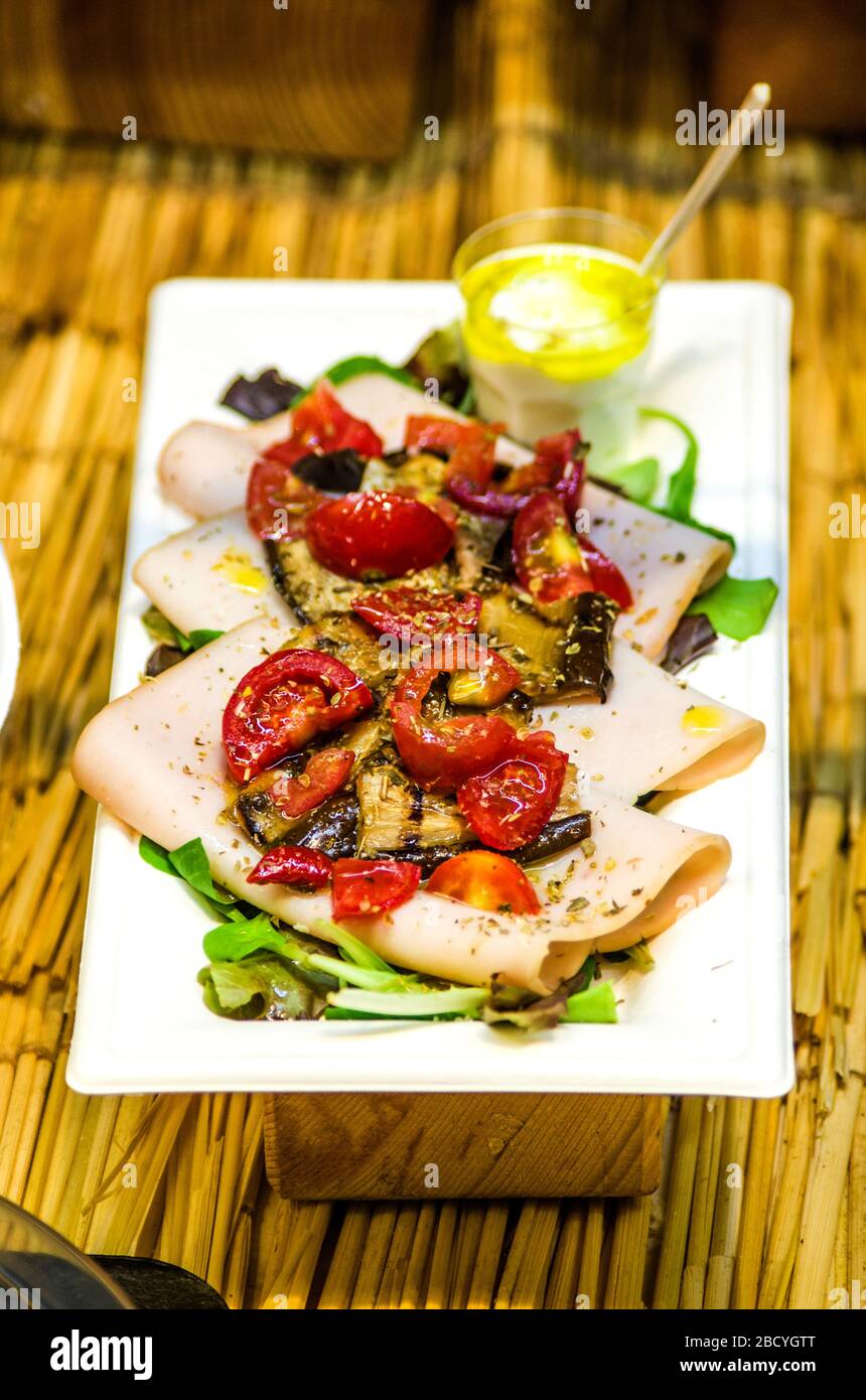 swordfish carpaccio with grilled vegetables and sautéed cherry tomatoes with savory herbs Stock Photo