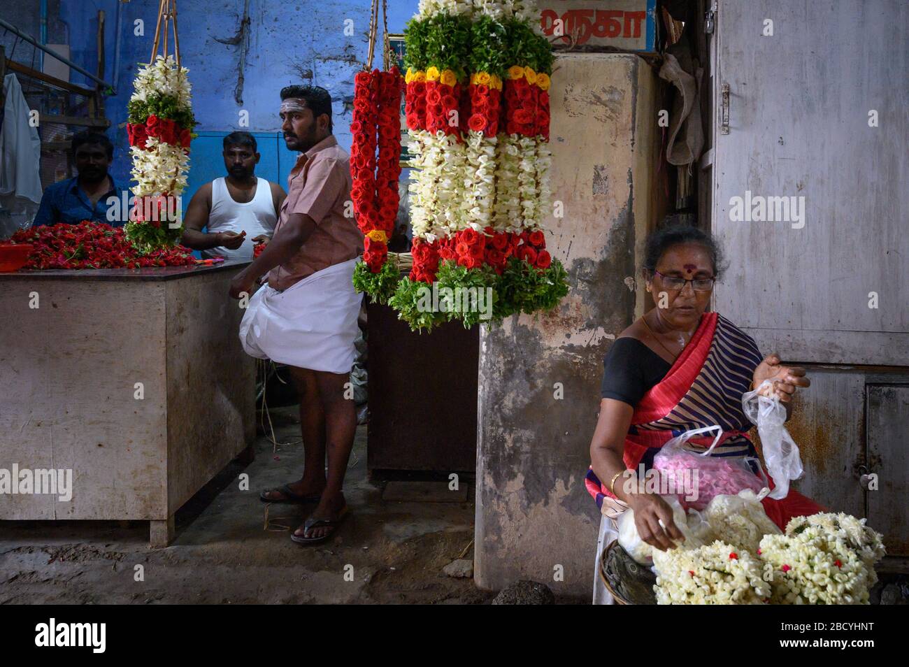 Woman sorting flowers on the grounds of Tiruchendur Murugan Temple, Tiruchendur, India Stock Photo