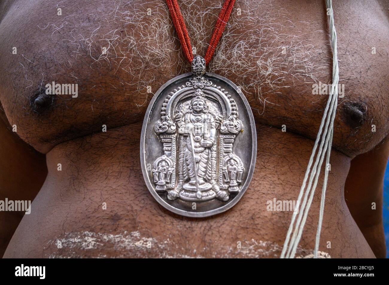 A medallion worn by a pilgrim on the grounds of Tiruchendur Murugan Temple, Tiruchendur, India Stock Photo